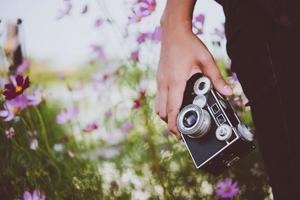 primo piano della donna hipster con fotocamera vintage foto