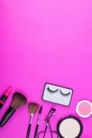 vista dall'alto di una collezione di prodotti cosmetici di bellezza su uno sfondo rosa