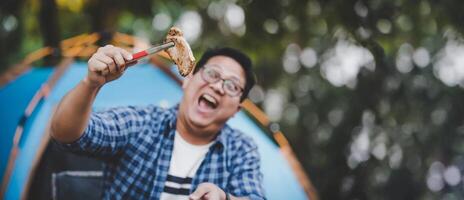 ritratto di asiatico viaggiatore uomo bicchieri Maiale bistecca frittura foto