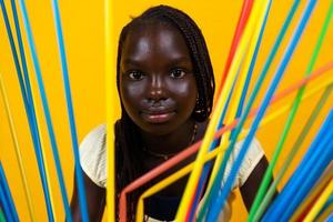 ritratto di giovane africano ragazza dietro a lungo colorato potabile cannucce foto