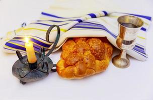 immagine dello shabbat. pane, vino e candele di challah sulla tavola di legno. foto