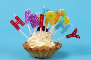 Cupcake con color arcobaleno candele per un' compleanno con il iscrizione contento compleanno foto