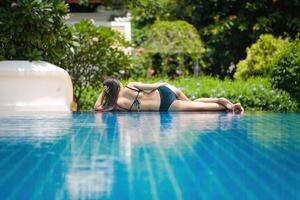 bellissimo sud-est Asia donna nel piscina rilassante. foto