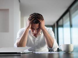 frustrato giovane attività commerciale uomo Lavorando su il computer portatile computer a casa foto