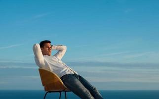 rilassato giovane uomo a casa su balcone foto