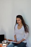 rilassato giovane donna a casa Lavorando su il computer portatile foto