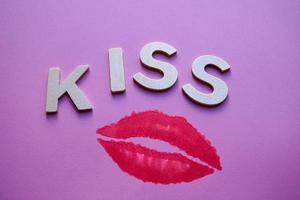 labbra e bacio parola con di legno lettere su il rosa sfondo foto