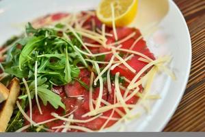 carpaccio di manzo con parmigiano su un piatto foto