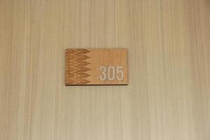 di legno appartamento, casa, o Hotel porta pavimento numero 305 isolato su legna parete con rettangolo sagomato modello. foto