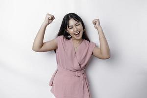 un' giovane asiatico donna con un' contento riuscito espressione indossare rosa camicetta isolato di bianca sfondo foto