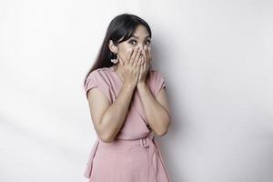 sorpreso giovane asiatico donna copertura bocca con mani e fissando a telecamera mentre in piedi contro bianca sfondo foto