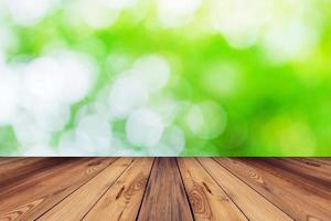 verde bokeh sfocatura sfondo e legna tavolo nel giardino foto