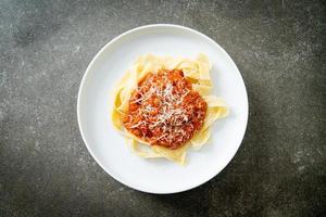 fettuccine alla bolognese di maiale con parmigiano foto