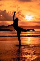 silhouette di un asiatico donna danza balletto con grande flessibilità e un' Visualizza di il onde dietro a sua foto