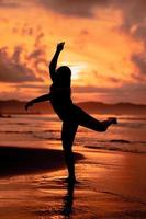 un asiatico adolescente danza balletto nel nero per un' Festival di il spiaggia foto