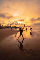 un' gruppo di asiatico donne danza insieme e pieno di gioia su il spiaggia foto