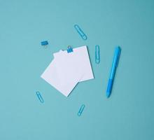pila di bianca piazza lenzuola di carta per Appunti, Stazionario su blu sfondo, superiore Visualizza foto