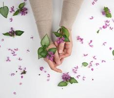 Due mani di un' giovane ragazza con liscio pelle e un' mazzo di rosa fiore foto