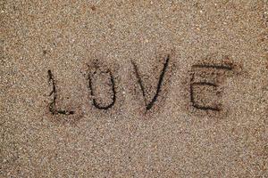 amore scritto sulla sabbia in spiaggia foto