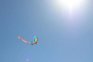 aquilone contro un' blu cielo con il leggero di il sole. sole bagliore e copia spazio. concetto di chasing il tuo sognare, fiducia in se stessi, obbiettivo realizzazione foto