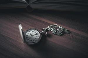 orologio da tasca su un tavolo di legno foto