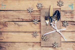 Natale tavolo posto ambientazione e argenteria, i fiocchi di neve su tavolo di legno sfondo con spazio per Natale. foto