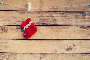 rosso calzino per Santa i regali sospeso al di sopra di rustico di legno sfondo. Natale calza foto