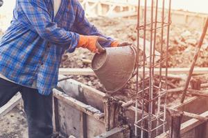 uomo lavoratore miscelazione cemento mortaio gesso per costruzione con Vintage ▾ tono. foto