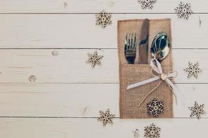 Natale tavolo posto ambientazione e argenteria, i fiocchi di neve su tavolo di legno sfondo con spazio per Natale. foto