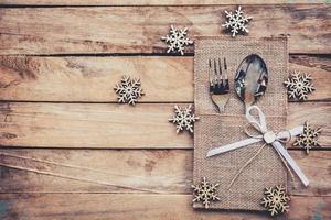 Natale tavolo posto ambientazione e argenteria, i fiocchi di neve su di legno sfondo con spazio. foto