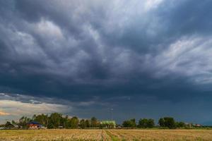 campo e tempesta nuvole di pioggia foto