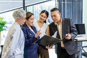 squadra di asiatico persone con diverso età gruppo di brainstorming su dati e informazione analisi per strategia gestione con giovane femmina capo per cooperazione e attività commerciale concetto foto