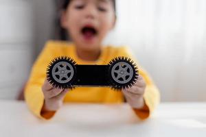 gli studenti asiatici imparano a casa a codificare auto robot e cavi di schede elettroniche in stelo, vapore, matematica ingegneria scienza tecnologia codice informatico in robotica per bambini concetto. foto