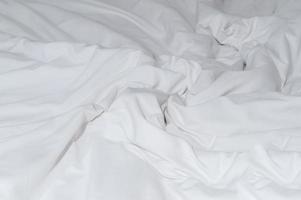 bianca spiegazzato o rugosa biancheria da letto foglio o coperta con modello dopo ospiti uso prese nel Hotel, ricorrere camera con copia spazio. disordinata coperta sfondo struttura foto