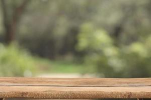 di legno rustico tavolo superiore su sfocato parco sfondo foto