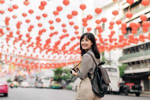 giovane asiatico donna zaino viaggiatore godendo Cina cittadina strada cibo mercato nel bangkok, Tailandia. viaggiatore controllo su lato strade. foto