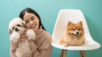 ritratto di giovane bellissimo donna baci e abbracci sua cane al di sopra di verde sfondo. foto