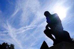 silhouette pensatore statua con tariffa leggero e blu cielo sfondo nel davanti di rodin Museo, Parigi Francia. foto