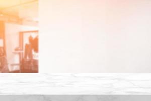 bianca marmo tavolo e sfocato parete di capi di abbigliamento boutique negozio con arancia leggero perdita sfondo, adatto per Prodotto presentazione sfondo, Schermo, e finto su. foto