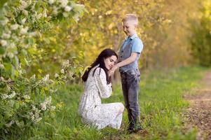 mamma con buio capelli abbracci sua figlio e sembra a lui foto