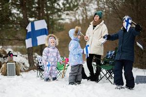 finlandese madre e bambini con Finlandia bandiere su un' simpatico inverno giorno. nordico scandinavo le persone. foto