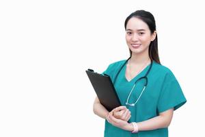 professionale asiatico bellissimo giovane donna medico in piedi sorridente nel un' verde laboratorio camicia, Tenere paziente documenti nel mano isolato su bianca sfondo. Salute cura concetto. foto