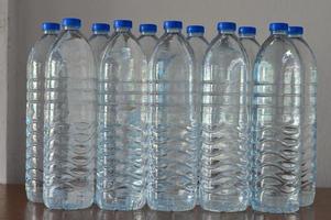 righe di bottiglie d'acqua in plastica sul tavolo foto