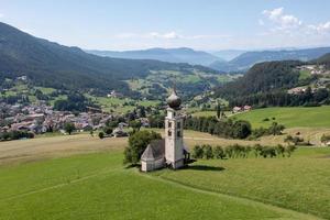 st. valentin castelrotto villaggio Chiesa nel il estate nel il dolomite Alpi. sorprendente paesaggio con piccolo cappella su soleggiato prato e petz picco a castelrotto comune. dolomiti, Sud tirolo, Italia foto