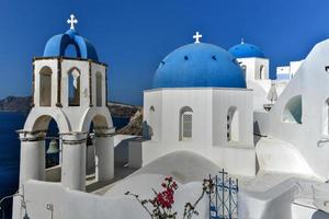 affascinante Visualizza Oia villaggio su santorini isola, Grecia. tradizionale famoso blu cupola Chiesa al di sopra di il caldera nel Egeo mare. tradizionale blu e bianca Cicladi architettura. foto
