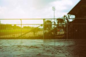 vicino su vecchio di legno tavolo con sfocato calcio campo sfondo e leggero perdere. foto