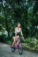 giovane donna in sella a una bicicletta nel parco
