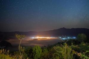 vista di una città e della via lattea foto