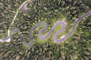 superiore aereo Visualizza di famoso serpente strada vicino passo giau nel dolomite Alpi. avvolgimento montagne strada nel lussureggiante foresta con verde abete rosso nel estate tempo nel il dolomiti, Italia foto