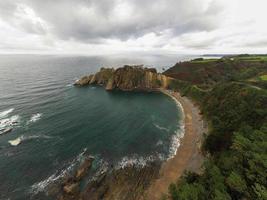 silenzio spiaggia, argento-sabbioso baia sostenuto di un' naturale roccia anfiteatro nel asturie, Spagna. foto